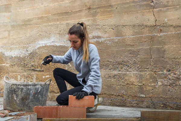 Maurerin bereitet Ziegelsteinverlegung für ihr eigenes Haus vor — Stockfoto