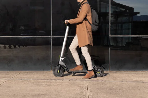 Homme d'affaires méconnaissable sur le trajet quotidien équitation micro scooter portant une tenue élégante et moderne en brun — Photo