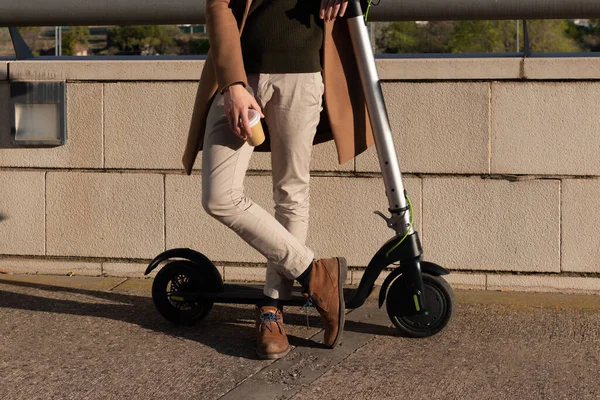 Schnappschuss eines jungen Geschäftsmannes, der auf einem Elektroroller von der Arbeit ruht und in seiner Freizeit Kaffeebecher zum Mitnehmen zur Hand hat — Stockfoto