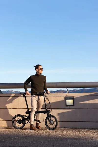 Junger, gutaussehender Mann fährt ein Elektrofahrrad als nachhaltige und umweltfreundliche Alternative zum Stadtbummel — Stockfoto