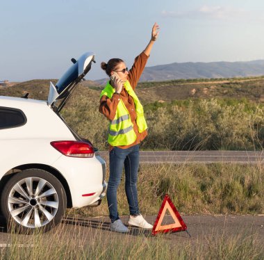 Çörek yiyen genç adam ona yardım etmek için telefondan araba sigortasını arıyor. Kolunu kaldır ki asistan onu görebilsin.