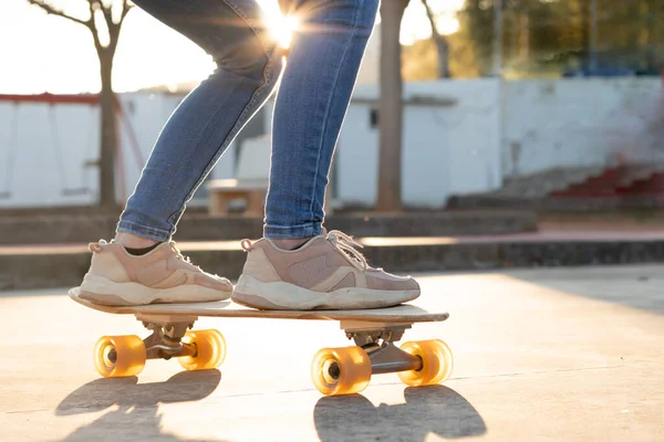 Neosobní detailní portrét dřevěného a růžového skateboad křižníku s dívkou v trenérech na něm — Stock fotografie