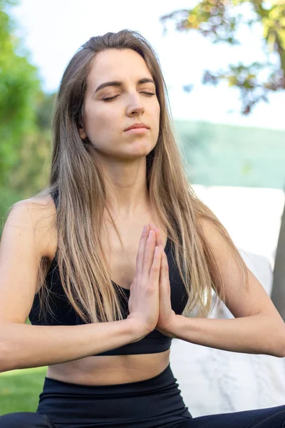 Retrato de una joven rubia hermosa practicando yoga en el jardín en un estilo de vida saludable y equilibrado — Foto de Stock