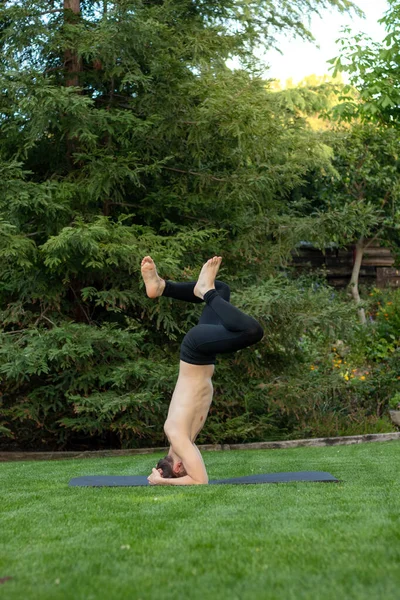 Bahçede başını paspasa dayayarak kendini dik duruma sokmaya çalışan genç adam.