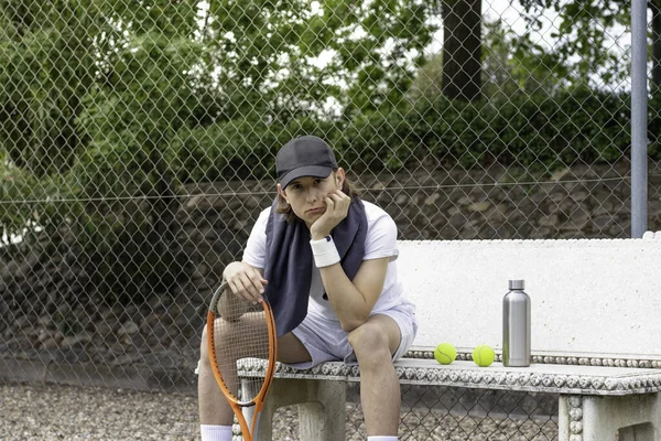 Retrato de un joven tenista profesional sentado mirando a la cámara con cara triste después de perder en un partido — Foto de Stock