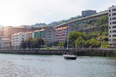 Bilbao, İspanya-Mayy, 5., 2022: Bilbao nehir kıyısında güneşli bir bahar günü yelkenli yelkenliyle nehir kenarına