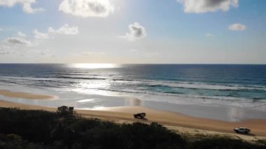 Üç 4WD aracının hava görüntüsü Fraser Adası kıyılarındaki kumları fırlatıyor, Queensland, Avustralya