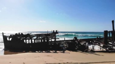 Genç adamın yürüyüşünün insansız hava aracı görüntüsü Fraser Adası, Queensland, Avustralya 'da Maheno' nun eski tekne enkazını fırlatıyor.