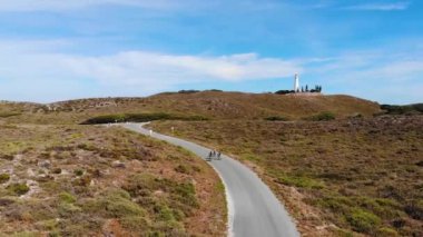 Batı Avustralya 'daki Rottnest Adası' nda arka planda deniz feneri olan dostların hava manzarası.