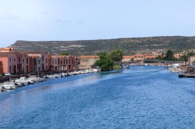 BOSA, SARDINIA, İTALYA - Haziran 09, 2022: Köydeki ana köprüden nehir manzaralı arka planda dağ
