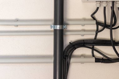 Odanın içindeki beyaz duvardaki elektrik ve su tesisatının görüntüsünü kapat