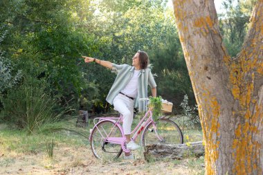 Mutlu genç adam, uzaktan bir şeyi işaret ederek mutlu bir şekilde işaret ediyor.