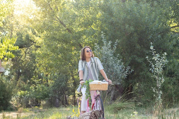 Genç, uzun saçlı, gülümseyen ve boş zamanlarında manzaranın tadını çıkaran bir adam.