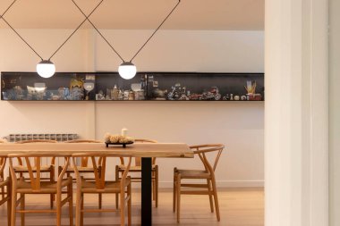 Büyük doğal ahşap masa ve sandalyelerle modern minimalist iç tasarımın ön görüntüsü