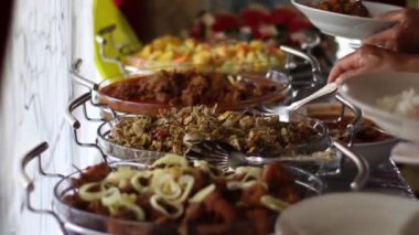 İnsanlar geleneksel Endonezya yemekleri alıyorlar. Mesela turşu, körili biftek ve biberli tofu.