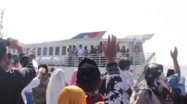İskelede yelken açmak üzere olan gemiye el sallayan insanların videosu.