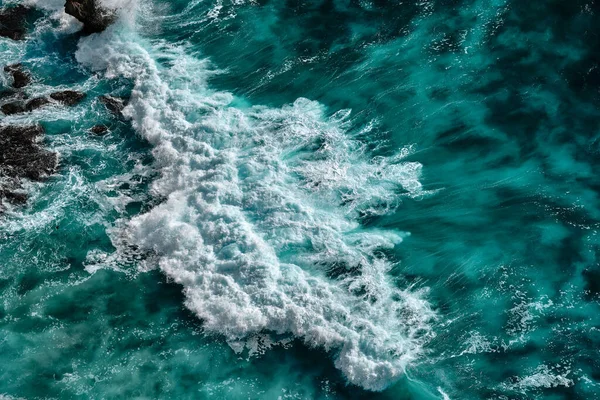 Köpükle kaynayan dalgalar için hava görüntüsü. Deniz dalgaları yüksek gelgitler ve alçak gelgitler sırasında bir araya gelir.