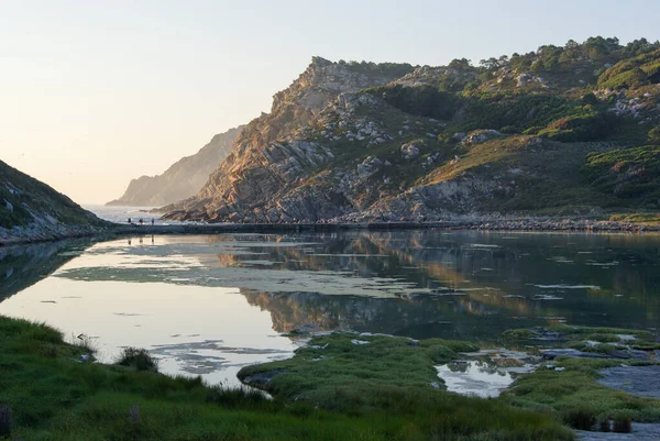 İnsanlar Cies Adası 'nda doğal bir göl ve deniz olan dar bir geçitten geçiyorlar.