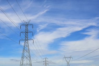 High voltage power transmission tower and sky background