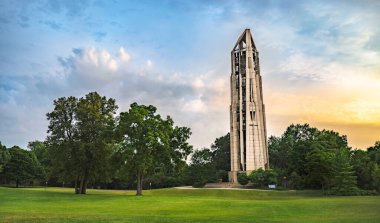 NAPERVILLE, IL, USA - JULY 14, 2018: The Millennium Carillon and Moser Tower were built in 1999 to commemorate the third millennium and 21st century. The area features concerts, parks, and activities. Sunset. clipart