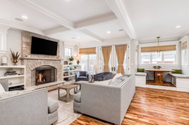 ELMURST, IL, ABD - 30 HAZİRAN 2020: Kanepe ve sandalyelerin önünde şöminenin üzerine televizyon monte edilmiş rahat bir oturma odası. Kahvaltı köşesi, bankta oturarak evin içine kurulur..