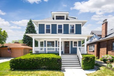 OAK PARK, IL, ABD - 24 Mayıs 2021: Mavi kaplamalı ve beyaz ön verandalı modern bir çiftlik evinin dışı.
