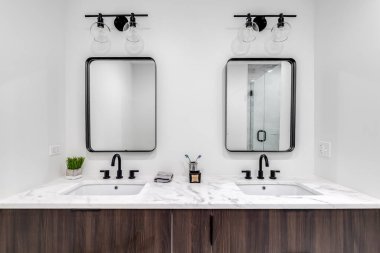 Chicago, IL, ABD - 7 Haziran 2020: ahşap kaplamalı, beyaz mermer tezgahlı ve özel döşenmiş duşlu güzel bir modern banyo.