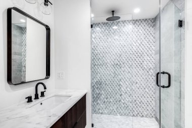 Chicago, IL, ABD - 7 Haziran 2020: ahşap kaplamalı, beyaz mermer tezgahlı ve özel döşenmiş duşlu güzel bir modern banyo.