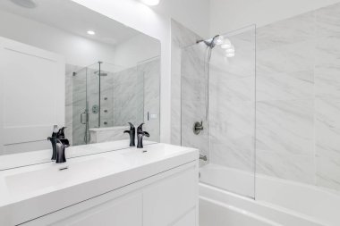 Şikago, IL, ABD - 27 Ocak 2020: Siyah donanım ve musluklarla dolu beyaz ana banyo kibri ve duşu kapı açık gösteriyor. Duşta cam duvarlar, kapı ve güzel fayanslar var..