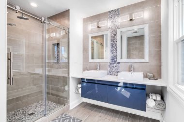 Şikago, IL, ABD - 18 Eylül 2019: Mavi bir dolap, fayans ve taş kaplama, döşeme / duş döşeme mermer kaplı modern bir banyo.