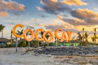 COCO CAY, BAHAMAS - 12 Ekim 2019, Royal Caribbean yolcu gemisinin özel adası Coco Cay, gün batımında. Misafirler teknelerinden adaya doğru yürürken tabelayı görüyorlar..