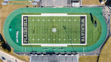 PLAINFIELD, IL, ABD - 19 Mart 2019: Plainfield Central Lisesi futbol ve futbol stadyumunun yeşil koşu pisti ile çevrili insansız hava aracı / hava görüntüsü.