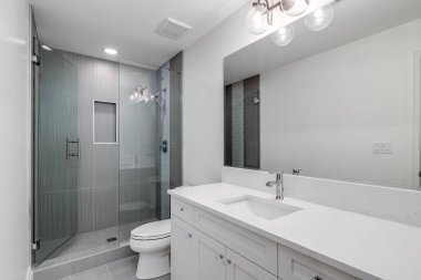 Şikago, IL, ABD - 17 Ağustos 2019: beyaz kibrli beyaz bir banyo ve gri seramikli duşlar.