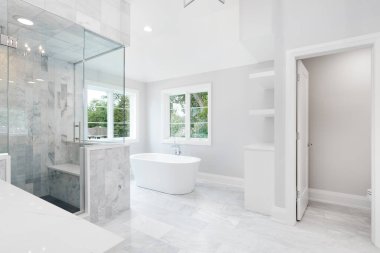 ELMHURST, IL, ABD - 17 Ağustos 2019: tek başına duran bir küveti, beyaz gösterişi ve mermer fayanslarla dolu cam bir duşu ve bank koltuğu olan büyük lüks bir banyo.