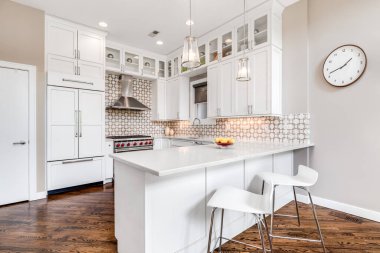 Şikago, IL, ABD - 19 Ağustos 2019 'da güzel bir arka fıskiyesi, Sıfır ve Kurt paslanmaz çelik aletleri ve mermer tezgahta oturan sandalyeleri olan lüks beyaz bir mutfak..