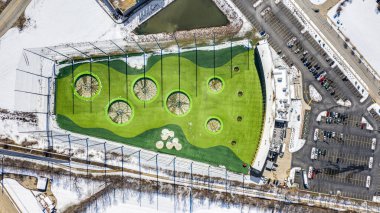 NAPERVILLE, IL, USA - APRIL 15, 2019: A drone / aerial view of TopGolf. Topgolf features three floors of driving range bays and is a fun entertainment complex for all ages to enjoy.  clipart