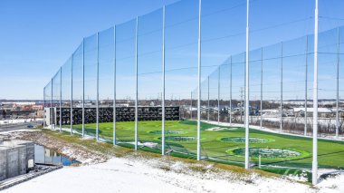 NAPERVILLE, IL, USA - APRIL 15, 2019: A drone / aerial view of TopGolf. Topgolf features three floors of driving range bays and is a fun entertainment complex for all ages to enjoy.  clipart