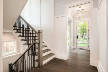 Şikago, IL, ABD - 17 Ağustos 2019: Yeni bir inşaat evi merdivenlerde demir parmaklıklar ve dış kapıya bakan yeşil ağaçlar ve bitkiler.