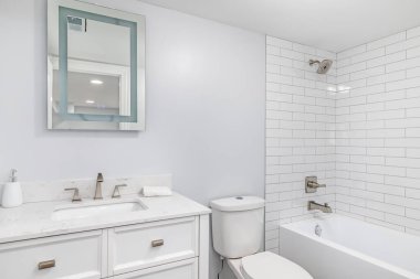 Şikago, IL, ABD - 7 Haziran 2020: Beyaz metro fayansları ve ışıklı bir ayna ile bembeyaz bir banyo.
