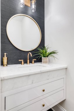 Chicago, IL, ABD - 7 Haziran 2020: Gri duvar kağıdı, altın donanım ve beyaz mermer tezgahlı küçük bir banyo.