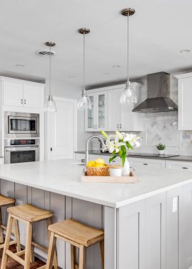 ELMHURST, IL, ABD - 4 Ağustos 2020: Ahşap döşemeleri, bar tabureleri, özel fayanslar ve paslanmaz çelikten yapılmış büyük lüks bir mutfak. Işıkları kapat..