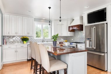 OAK PARK, IL, ABD - 19 Eylül 2020: Paslanmaz çelik GE cihazları, beyaz ve gri dolaplar ve buzdolabının üzerine monte edilmiş bir televizyon ile yeni yenilenmiş bir mutfak.