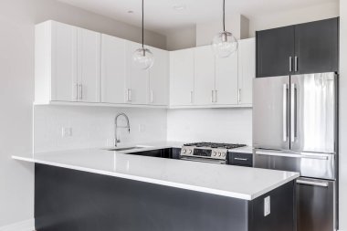 Chicago, IL, ABD - 30 Eylül 2020: Mermer tezgahın üzerinde asılı iki tonlu siyah beyaz mutfak, paslanmaz çelik aletler ve beyaz metro fayansları.