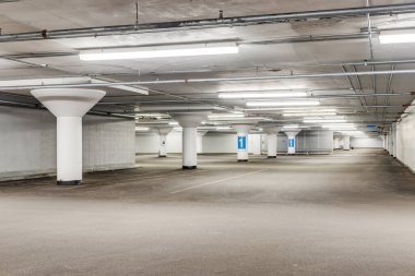 Sarı çizgileri ve beyaz sütunları olan boş bir otopark..