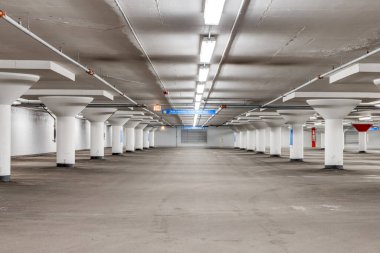 Sarı çizgileri ve beyaz sütunları olan boş bir otopark..