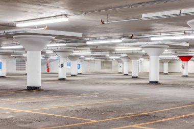 Sarı çizgileri ve beyaz sütunları olan boş bir otopark..
