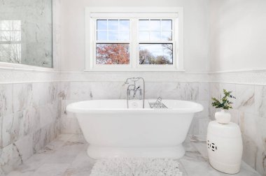ELMHURST, IL, ABD - 4 Kasım 2020: Victoria + Albert banyo küveti ve krom musluğu yer ve duvarlarda mermer fayanslarla çevrili lüks bir banyo.
