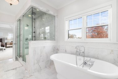 ELMHURST, IL, ABD - 4 Kasım 2020: güzel Victoria + Albert serbest döşemeleri, büyük cam bir duş ve büyük bir birinci yatak odası manzaralı lüks bir banyo.
