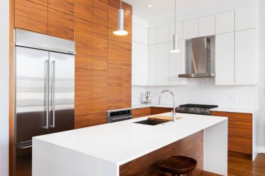 Şikago, IL, ABD - 1 Kasım 2020: Ahşap ve beyaz dolapları, beyaz şelale granit adası, KitchenAid cihazları ve beyaz beşgen döşeme döşemeleri olan modern, yenilenmiş bir mutfak.