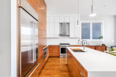 Şikago, IL, ABD - 1 Kasım 2020: Ahşap ve beyaz dolapları, beyaz şelale granit adası, KitchenAid cihazları ve beyaz beşgen döşeme döşemeleri olan modern, yenilenmiş bir mutfak.